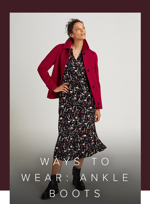 Photographed next to a contemporary armchair, model wears a printed fit and flare linen dress.